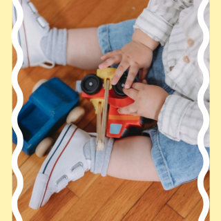 Little boy playing with wooden cars